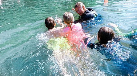 Barn som simmar med simlärare