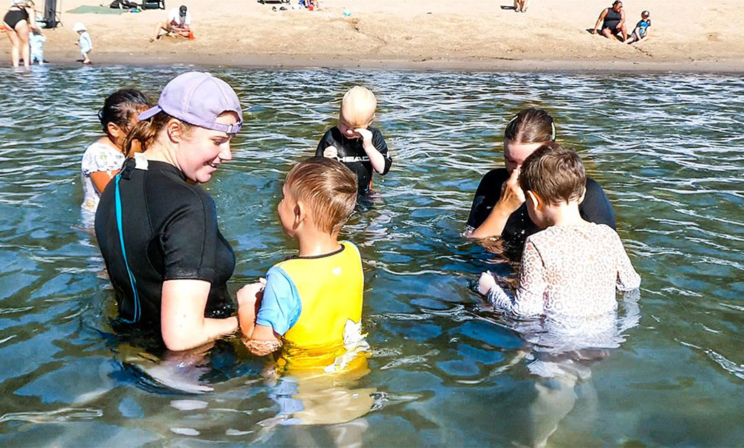 Simlärare och simlekisbarn - blöta i håret efter att ha klarat att doppa huvudet